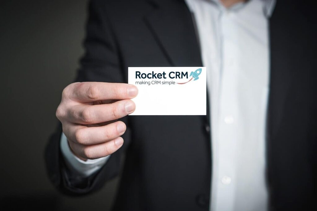 business person hlding business card with Rocket CRM logo