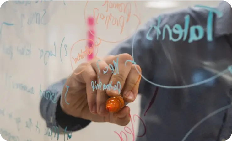 man writing noted and ideas on transparent board in workshop