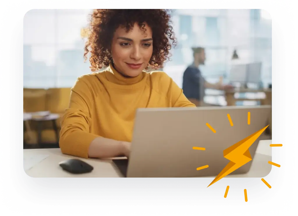 A woman wearing a yellow jumper smiles at her laptop in an office, with a lightning bolt graphic indicating energy and empowerment.